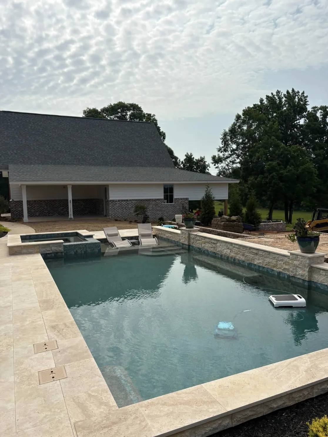 Pool and spa combo set against a covered farmhouse patio