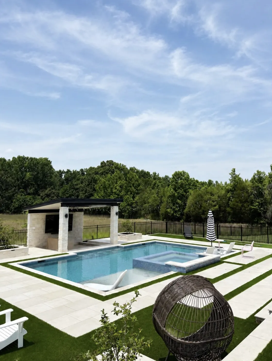 Pool and spa paired with a covered outdoor living pavilion featuring an outdoor TV